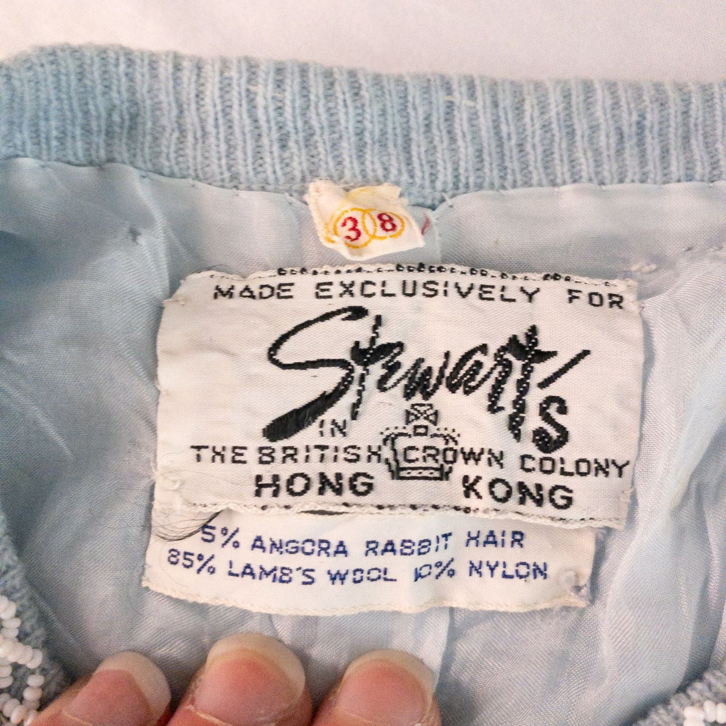 Stewarts pastel blue vintage cardigan with white bead floral embellishments and pearl buttons on a hanger image 15
