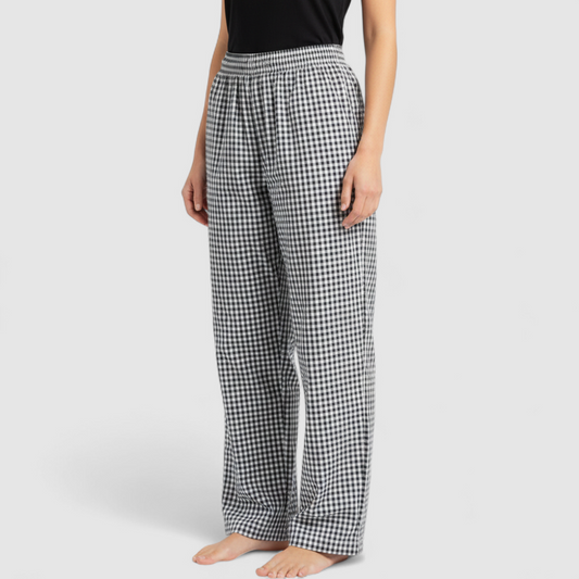 Mercer Culinary black and white houndstooth high rise pants in womens small size hanging on plastic hanger against white background showing front, side pockets, and back Mercer Culinary logo on model