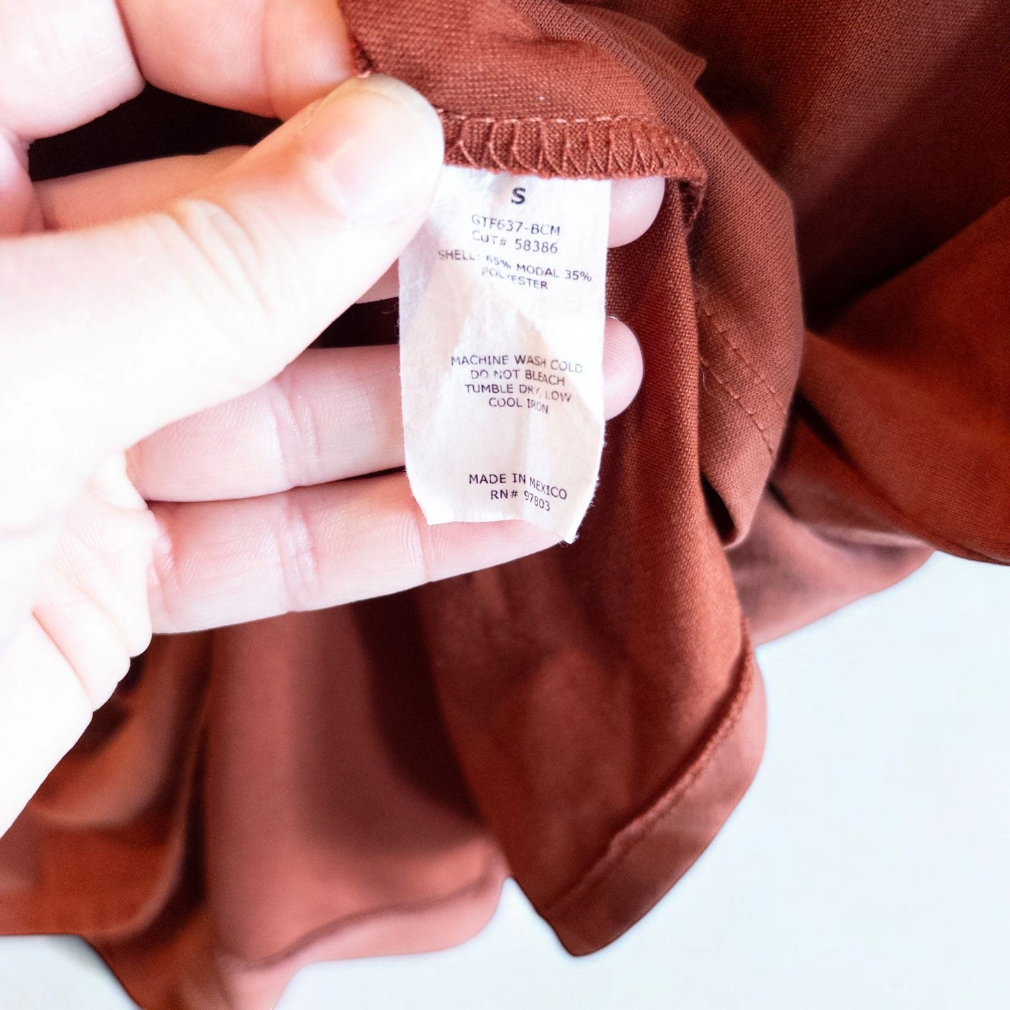 Green Envelope rust color womens small button back shirt hanging on white background image 4
