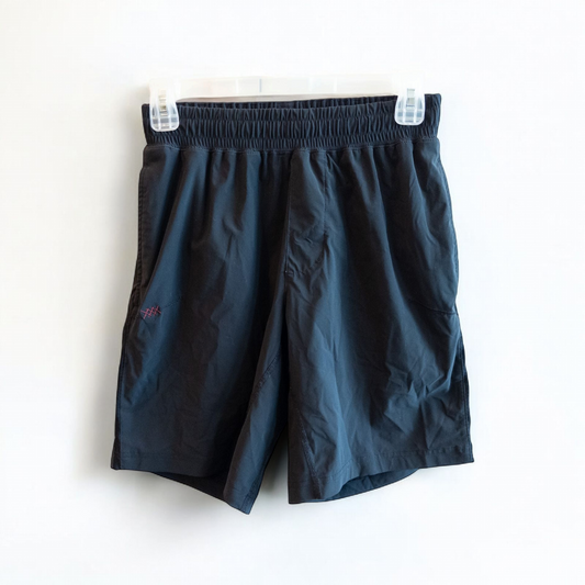 Rhone black athletic shorts for men with elastic waistband and zippered pockets hanging on hanger