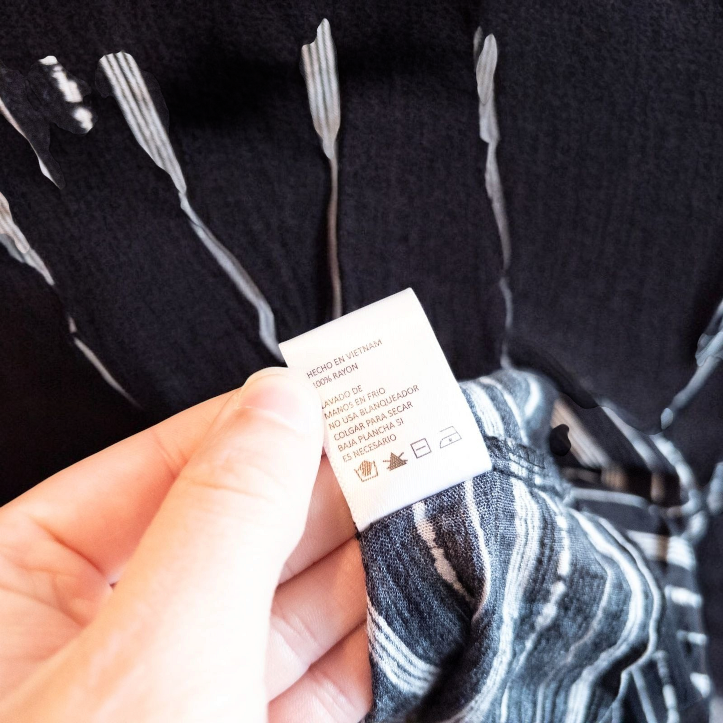 Paper Crane black and white striped peplum blouse with round neck and flutter sleeves hanging on white door image 7