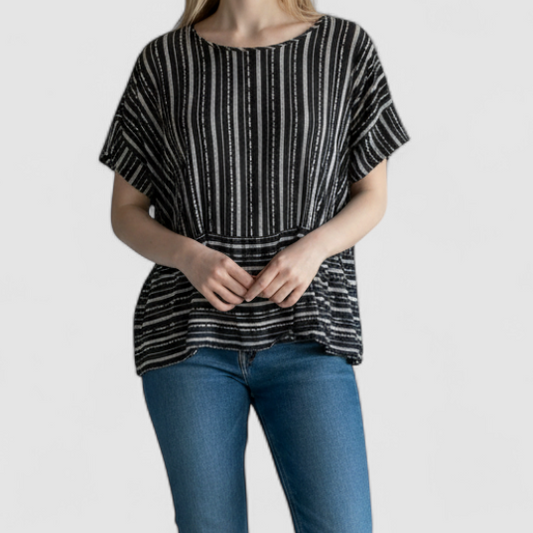 Paper Crane black and white striped peplum blouse with round neck and flutter sleeves hanging on white door on model