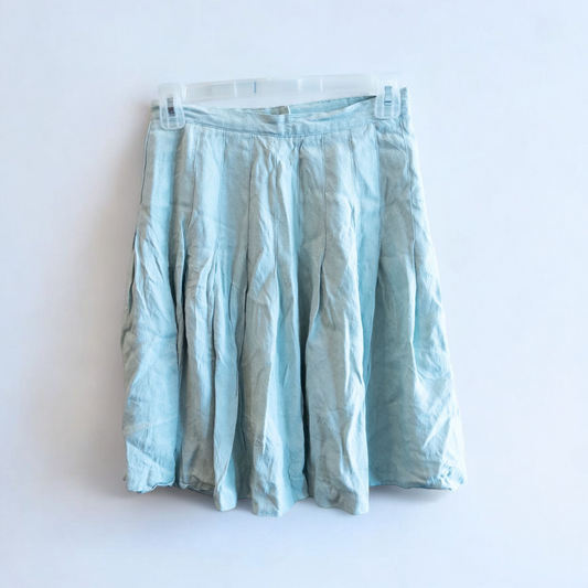 Casual Corner vintage pastel green pleated mini skirt with textured fabric hanging on clear hanger