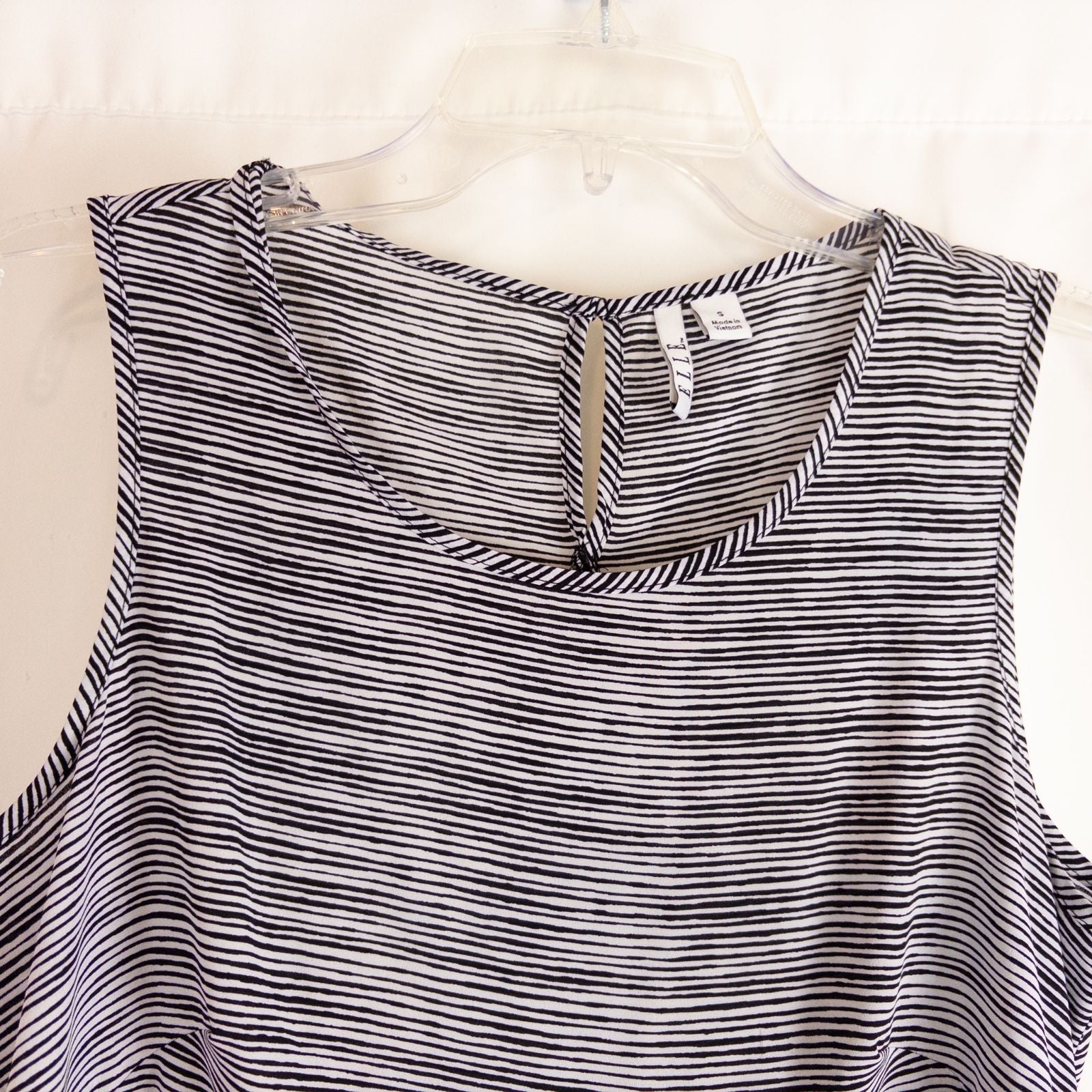 Elle black and white striped sleeveless tank top with peplum hem on clear hanger image 2