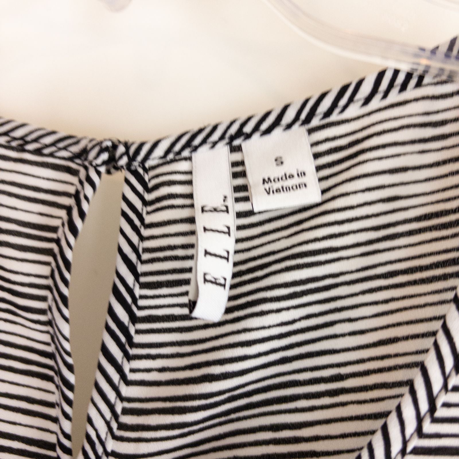 Elle black and white striped sleeveless tank top with peplum hem on clear hanger image 6