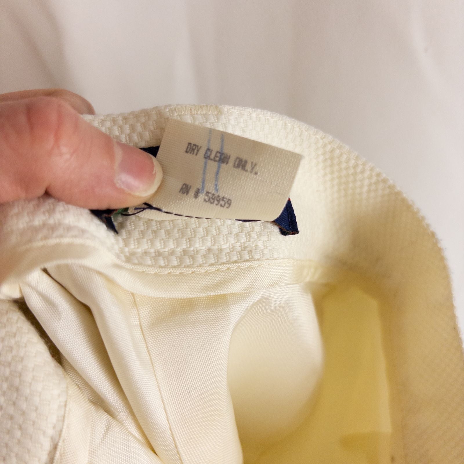 Vintage ivory pique pencil skirt with side zipper and button tab detail hanging on a hanger image 11