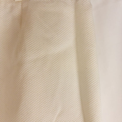 Vintage ivory pique pencil skirt with side zipper and button tab detail hanging on a hanger image 3
