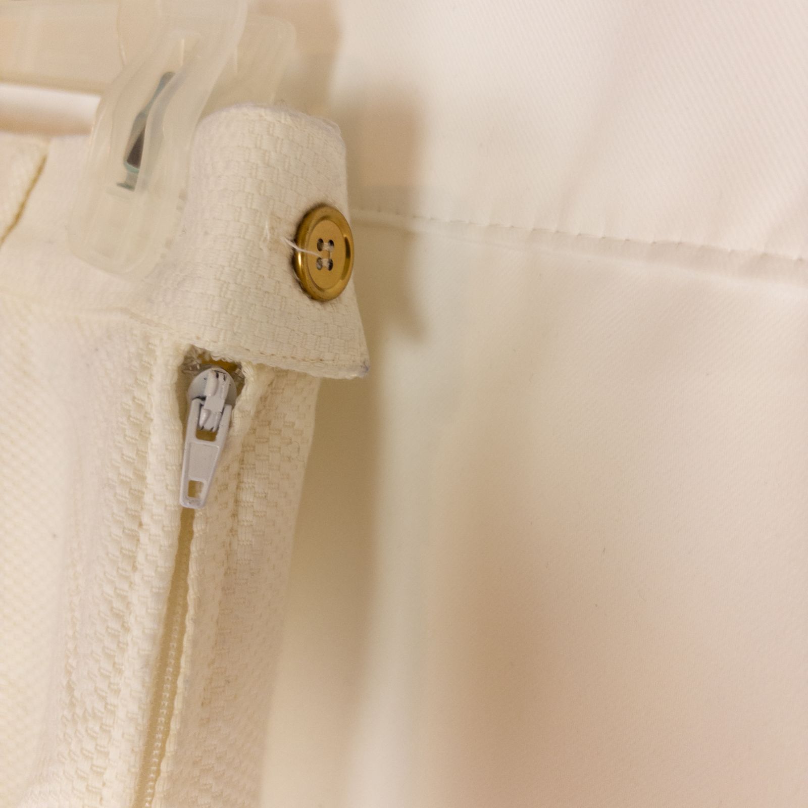 Vintage ivory pique pencil skirt with side zipper and button tab detail hanging on a hanger image 4