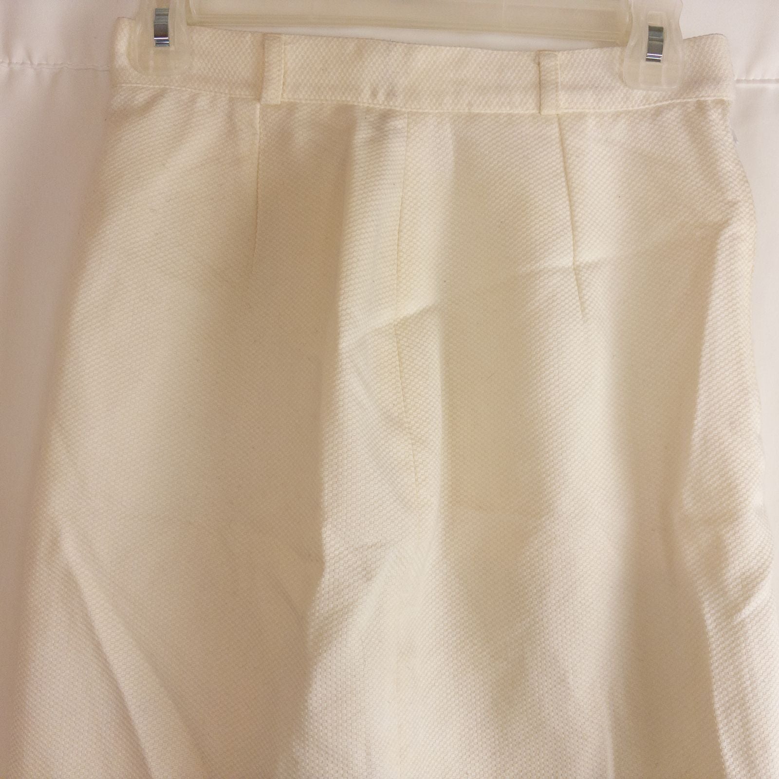 Vintage ivory pique pencil skirt with side zipper and button tab detail hanging on a hanger image 2
