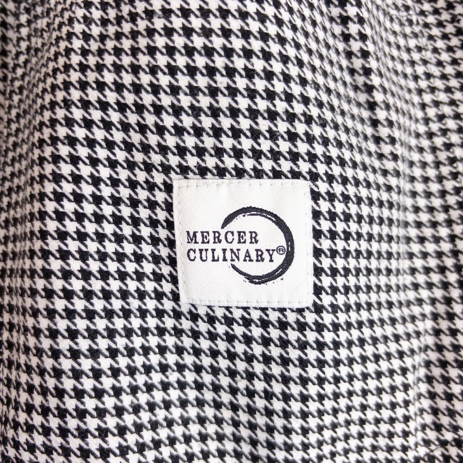 Mercer Culinary black and white houndstooth high rise pants in womens small size hanging on plastic hanger against white background showing front, side pockets, and back Mercer Culinary logo image 8