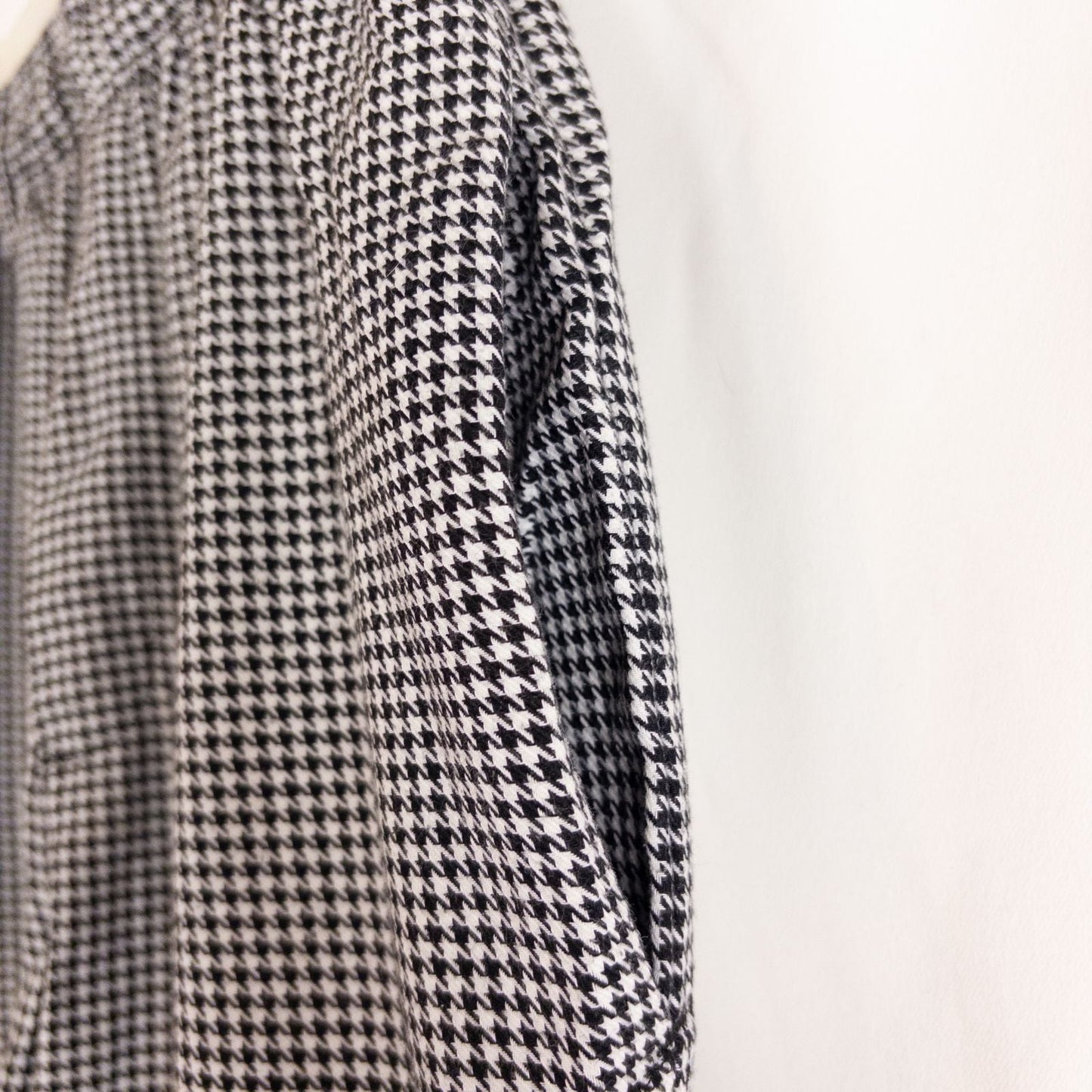 Mercer Culinary black and white houndstooth high rise pants in womens small size hanging on plastic hanger against white background showing front, side pockets, and back Mercer Culinary logo image 4