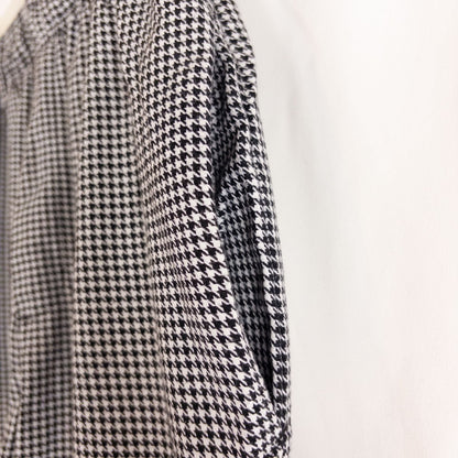 Mercer Culinary black and white houndstooth high rise pants in womens small size hanging on plastic hanger against white background showing front, side pockets, and back Mercer Culinary logo image 4