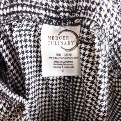 Mercer Culinary black and white houndstooth high rise pants in womens small size hanging on plastic hanger against white background showing front, side pockets, and back Mercer Culinary logo image 10