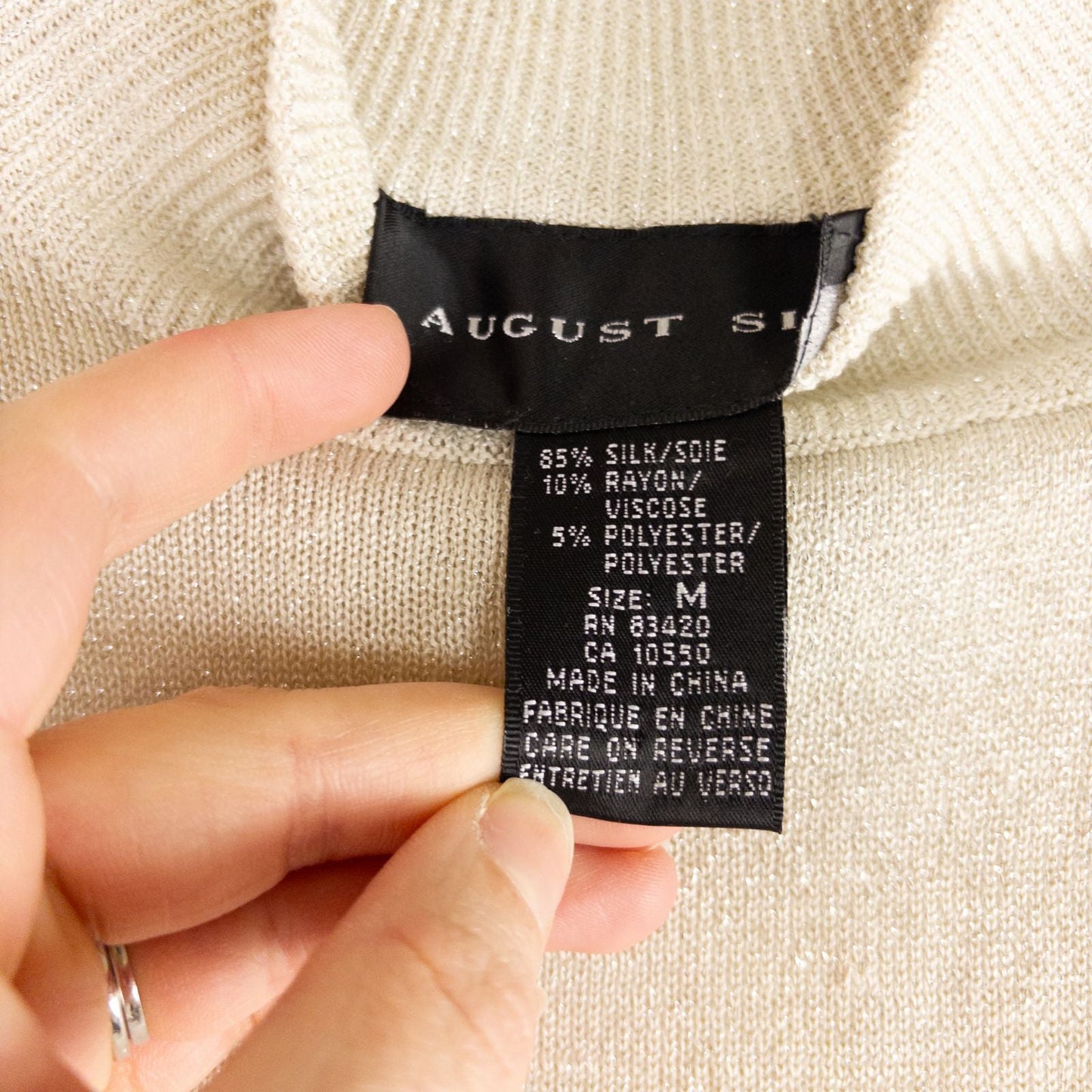 Silver knit long sleeve August Silk sweater with mock neckline laid flat showing subtle shimmer and texture image 10