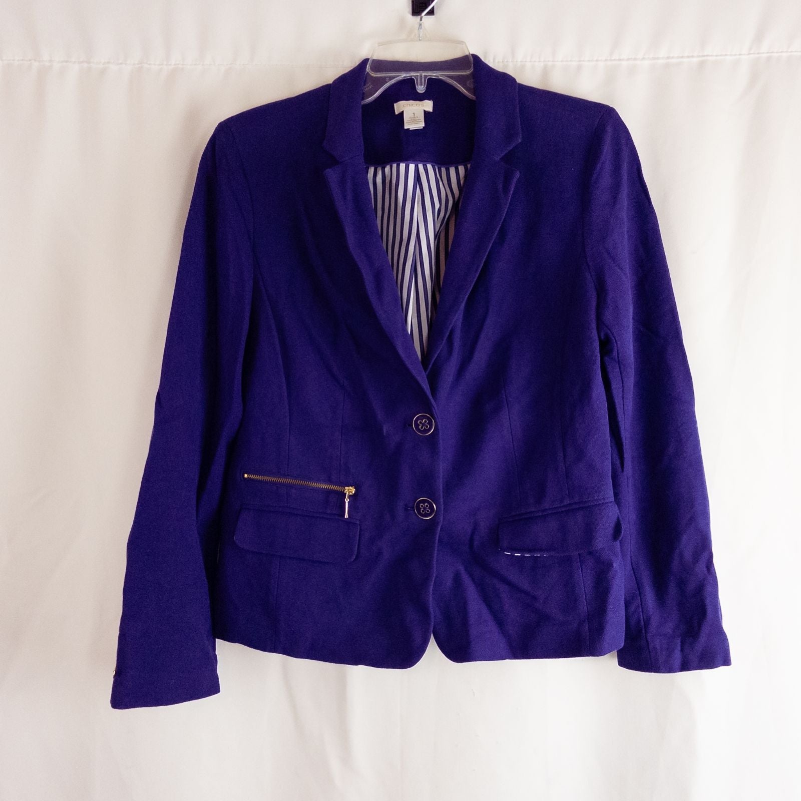 Chicos women's dark purple blazer with striped lining hanging on hanger