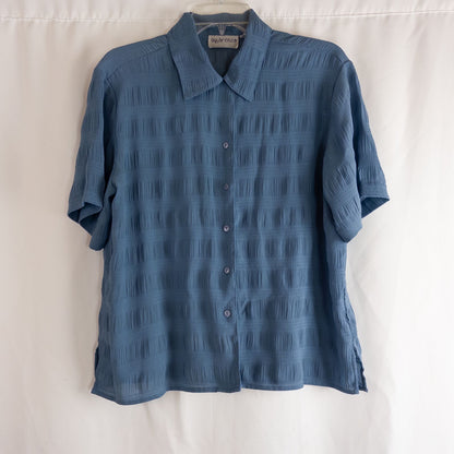 Apparenza vintage pastel blue textured button-up shirt with pointed collar and short sleeves hanging on hanger