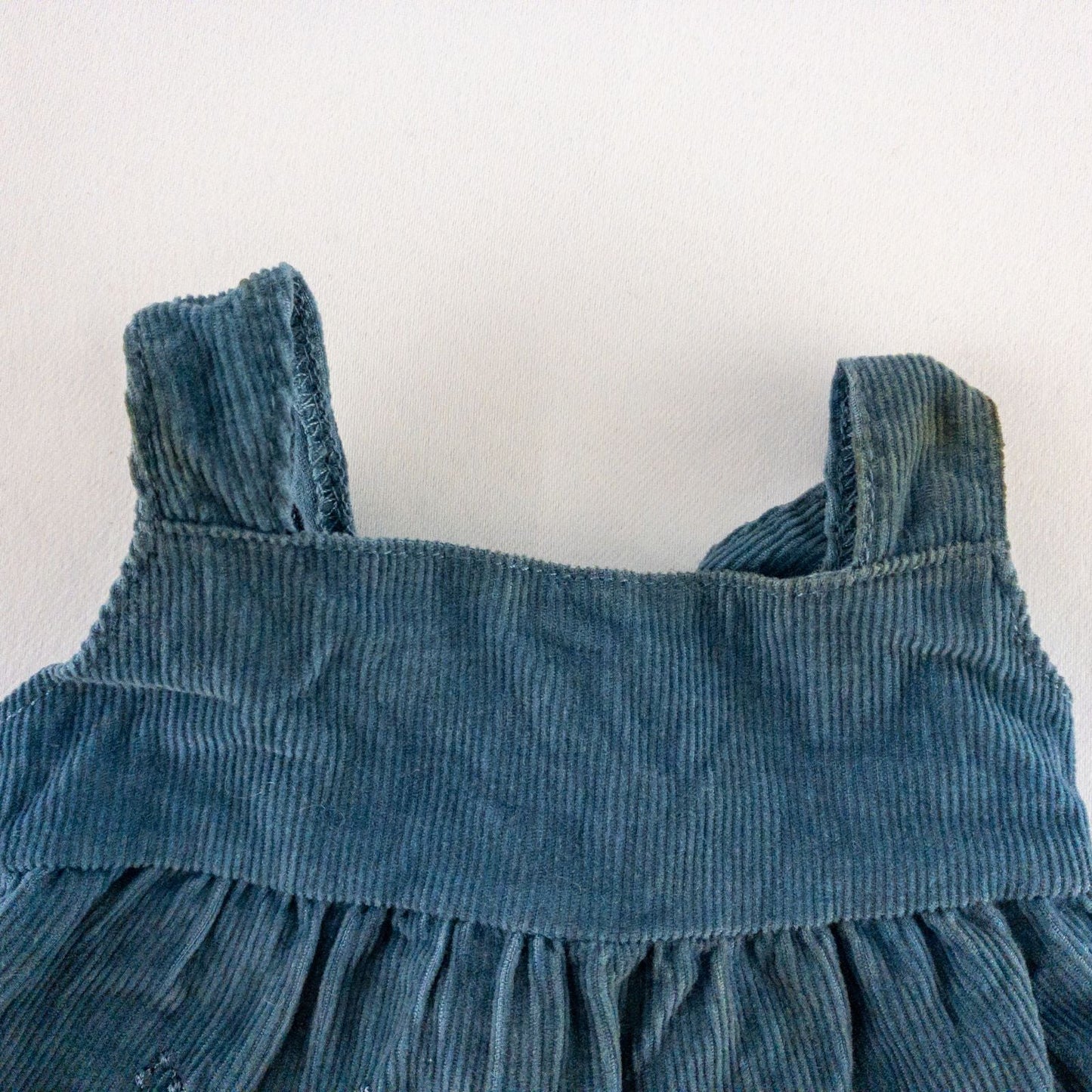 American Girl doll jumper dress outfit with blue corduroy jumper dress, faded light blue long sleeve top, and blue doll boots laid flat on white background image 3