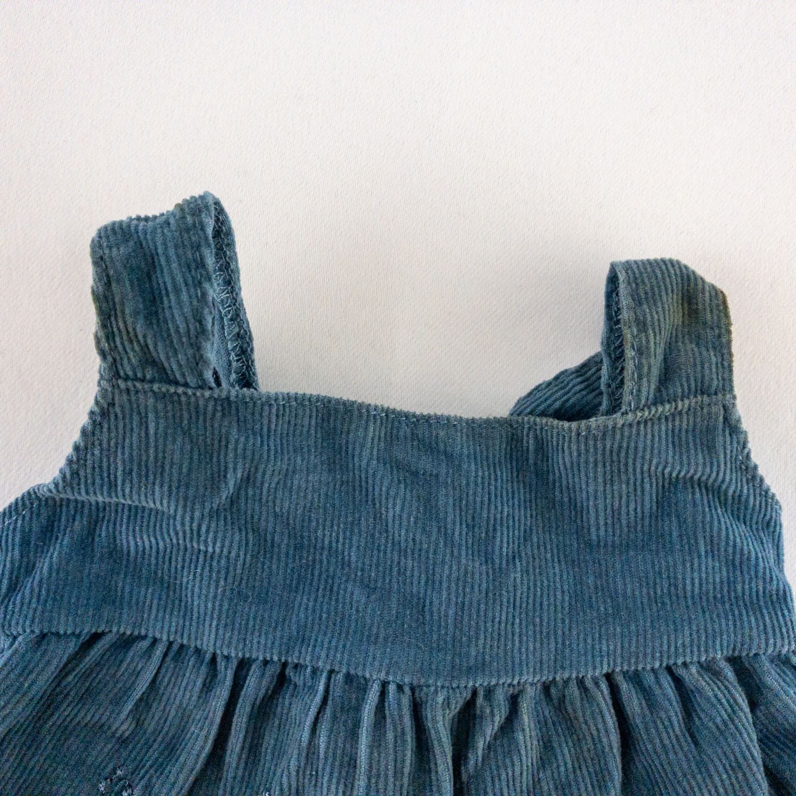 American Girl doll jumper dress outfit with blue corduroy jumper dress, faded light blue long sleeve top, and blue doll boots laid flat on white background image 3
