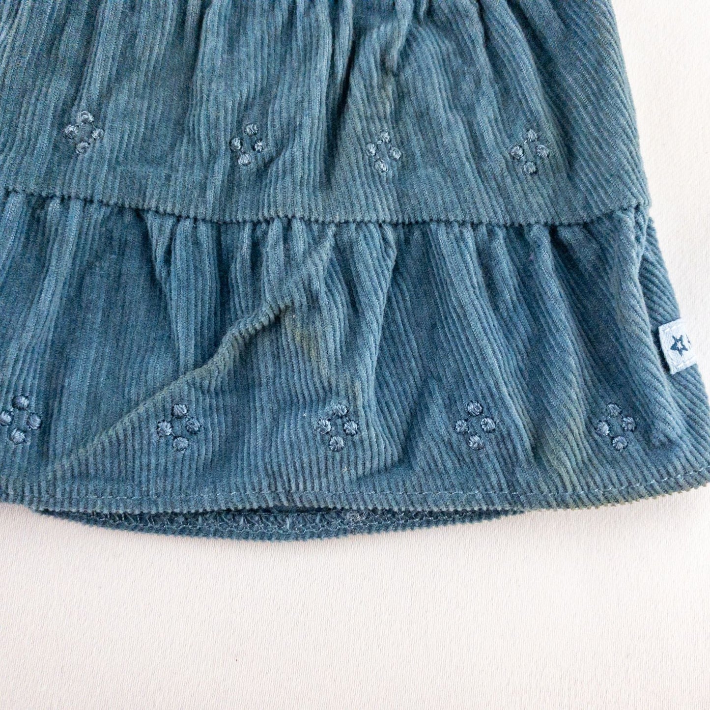 American Girl doll jumper dress outfit with blue corduroy jumper dress, faded light blue long sleeve top, and blue doll boots laid flat on white background image 4