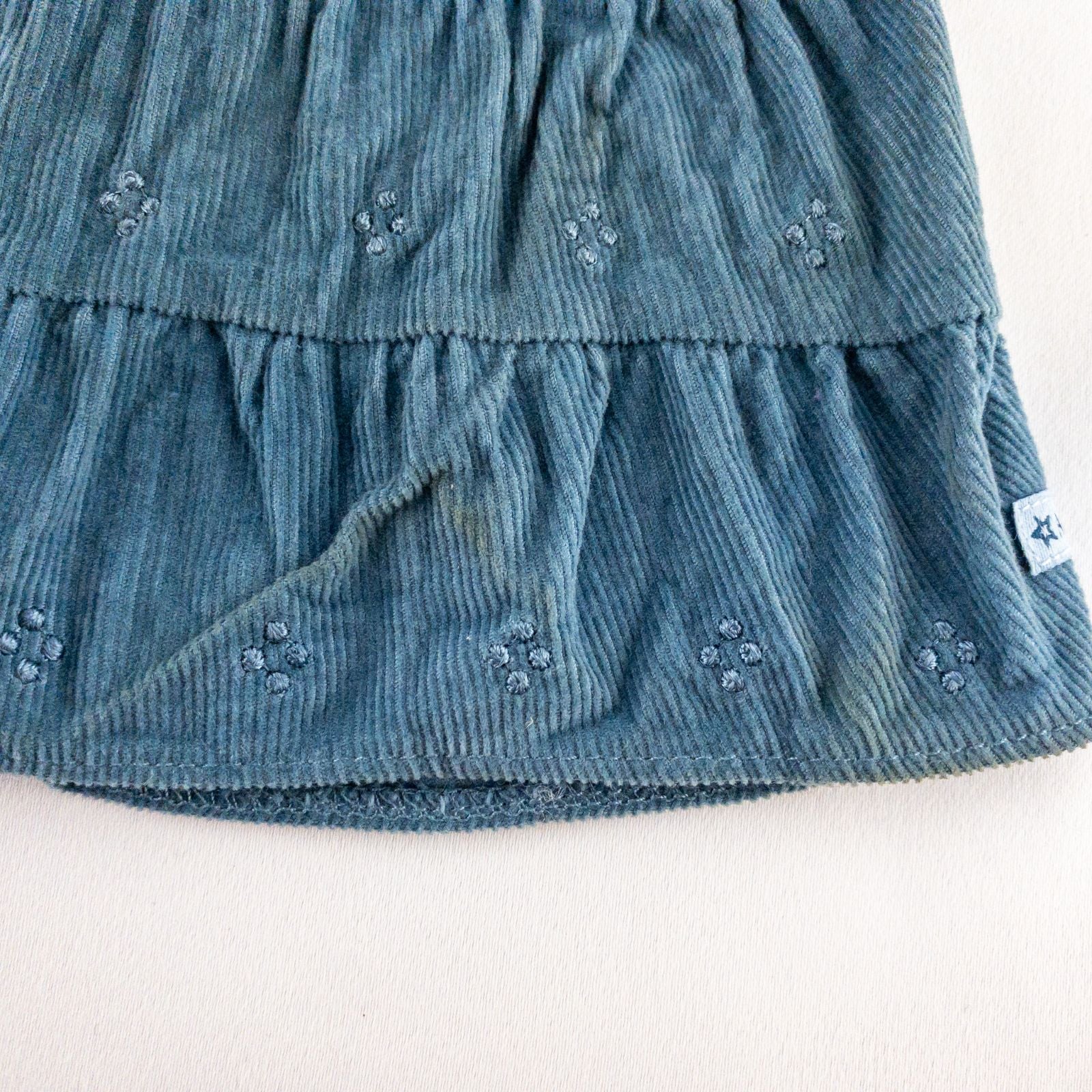 American Girl doll jumper dress outfit with blue corduroy jumper dress, faded light blue long sleeve top, and blue doll boots laid flat on white background image 4