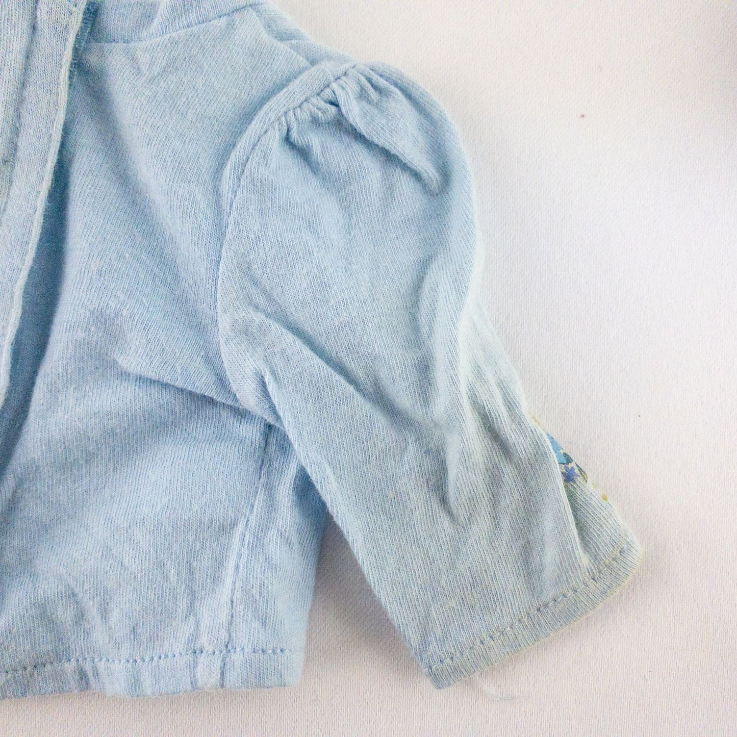 American Girl doll jumper dress outfit with blue corduroy jumper dress, faded light blue long sleeve top, and blue doll boots laid flat on white background image 11