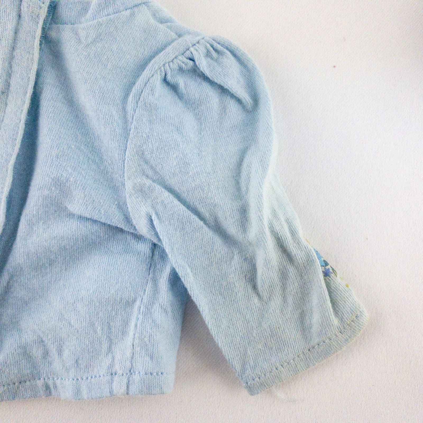 American Girl doll jumper dress outfit with blue corduroy jumper dress, faded light blue long sleeve top, and blue doll boots laid flat on white background image 11