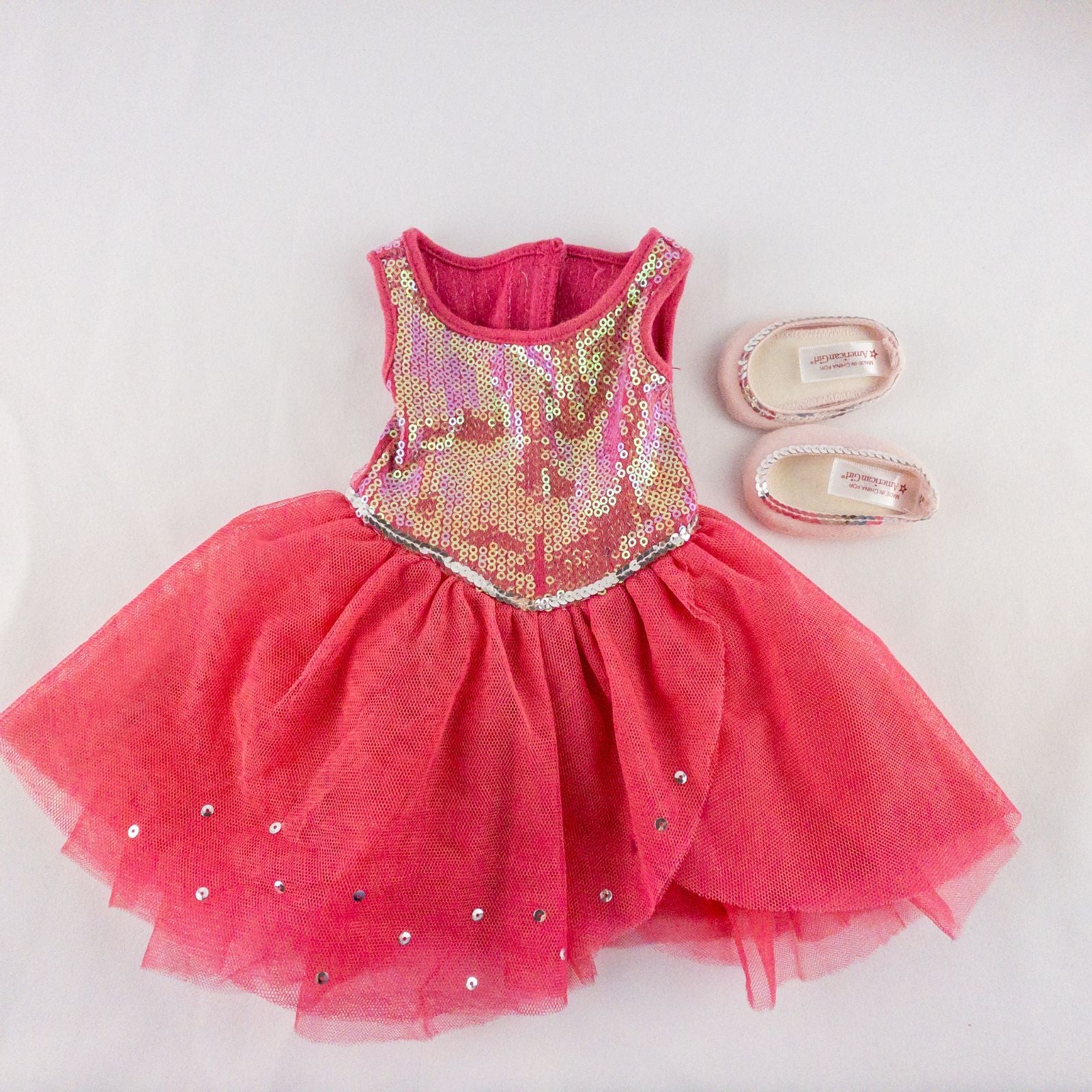American Girl pink ballet dress with sequin bodice and tulle skirt with matching slippers laid flat on white background showing front and back details