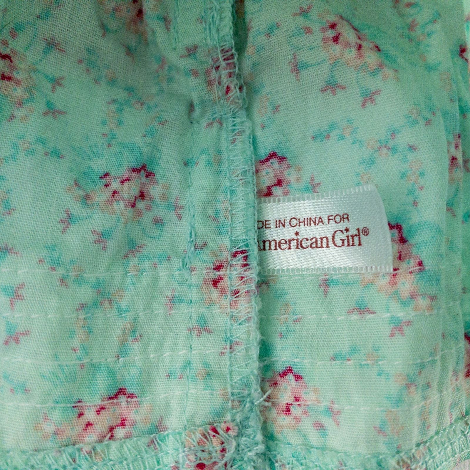 American Girl doll dress set including green floral doll dress with lace trim and pink bow sash, pink bow headband, white stockings, and red patent shoes image 6