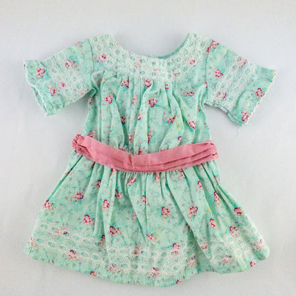American Girl doll dress set including green floral doll dress with lace trim and pink bow sash, pink bow headband, white stockings, and red patent shoes image 2