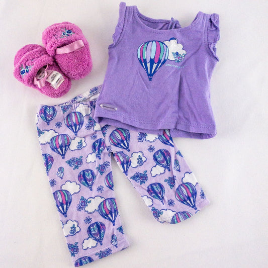 American Girl doll outfit featuring purple sleeveless top with hot air balloon print, matching pajama bottoms with hot air balloons, and pink fuzzy slippers