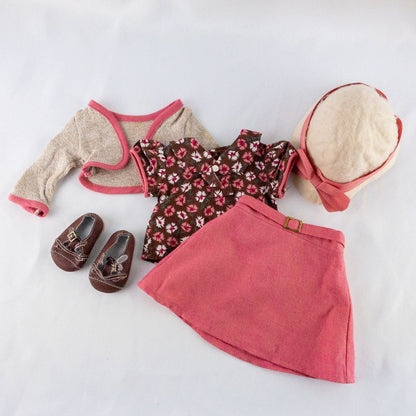 American Girl doll outfit set with floral top, pink skirt, cropped cardigan, hat, and tiny shoes laid flat