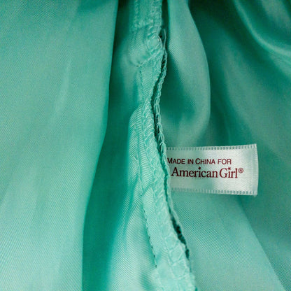 American Girl vintage green emerald doll dress with layered tulle skirt, pink flower belt detail, matching green headband, and red shoes with white bows image 8