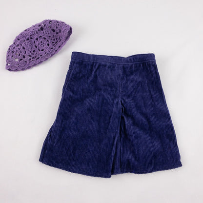 American Girl purple corduroy gaucho pants with matching purple crochet hat laid flat on white background