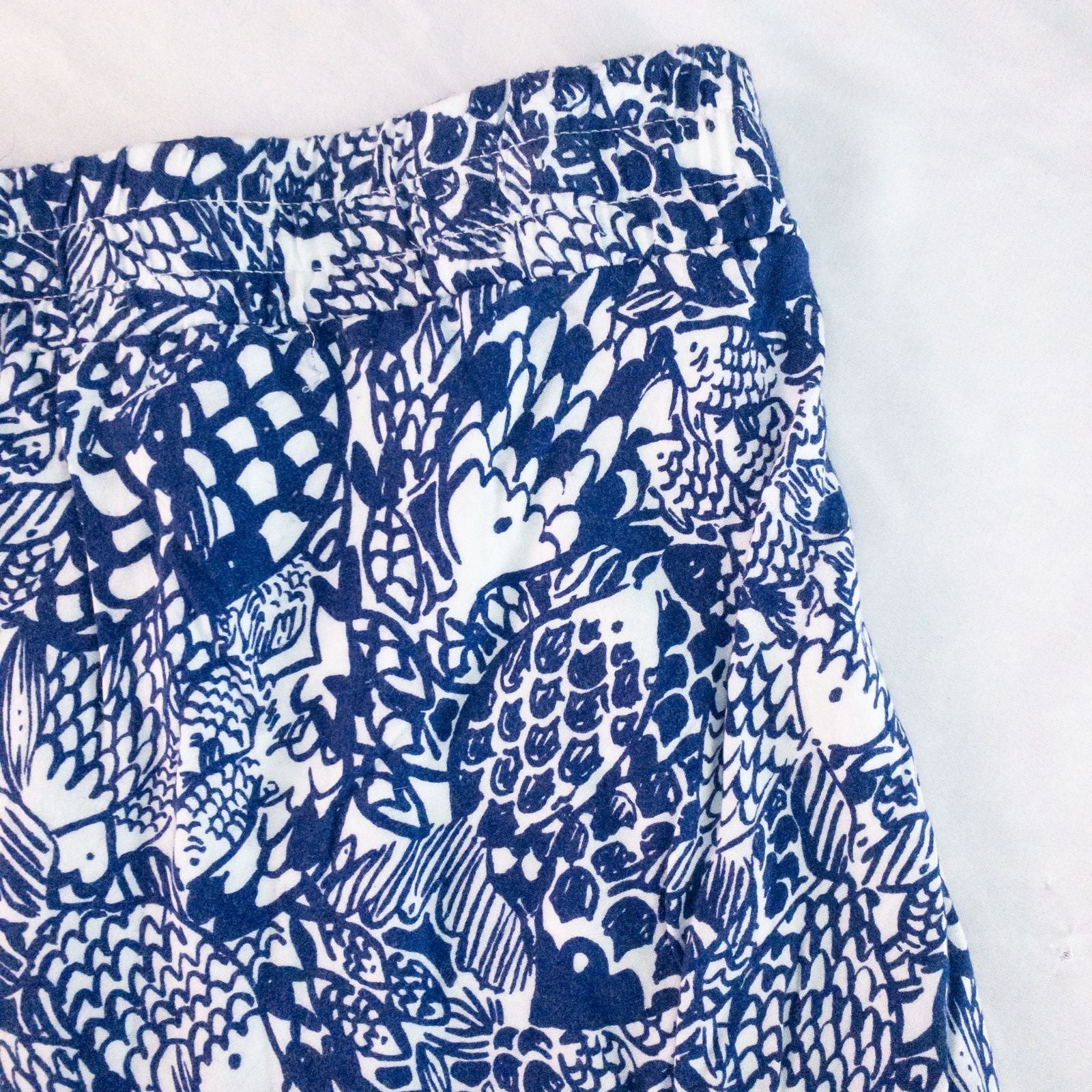 Lily Pullitzer blue fish print lounge shorts with pom pom trim and drawstring waistband laid flat image 9