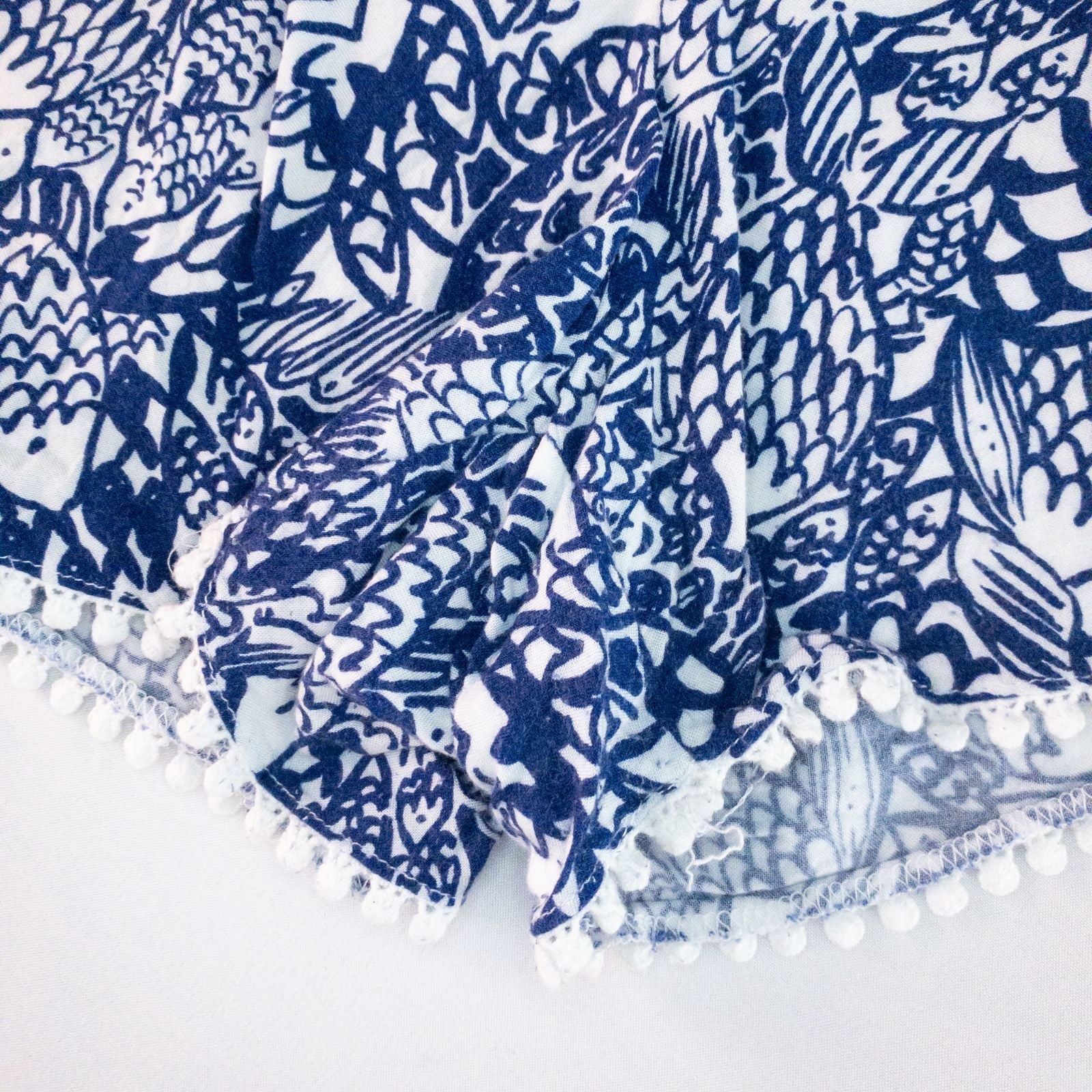 Lily Pullitzer blue fish print lounge shorts with pom pom trim and drawstring waistband laid flat image 5