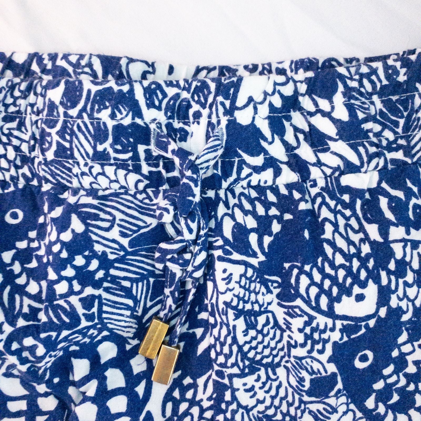 Lily Pullitzer blue fish print lounge shorts with pom pom trim and drawstring waistband laid flat image 4