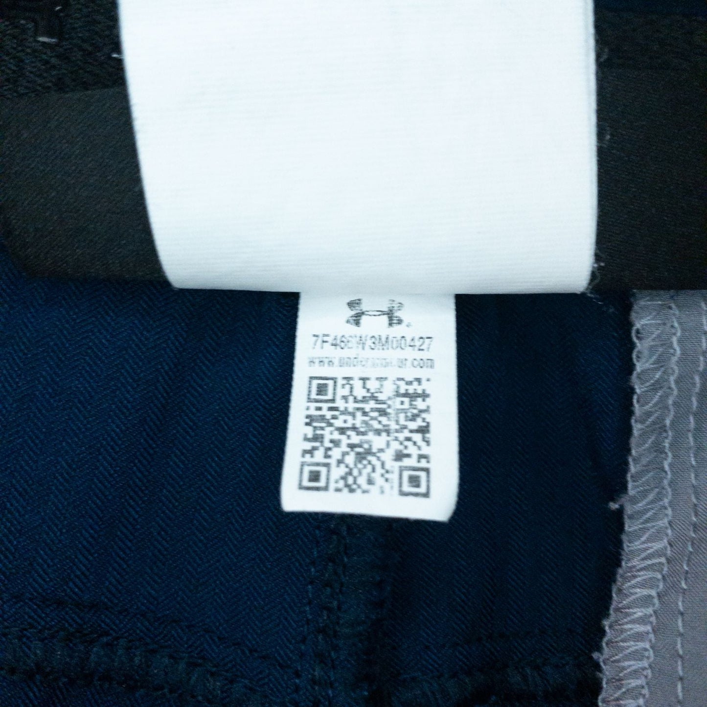 Under Armour navy men's shorts laid flat showing front and back views with button and logo details image 14