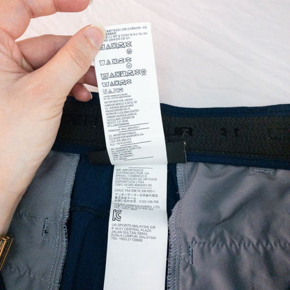 Under Armour navy men's shorts laid flat showing front and back views with button and logo details image 13