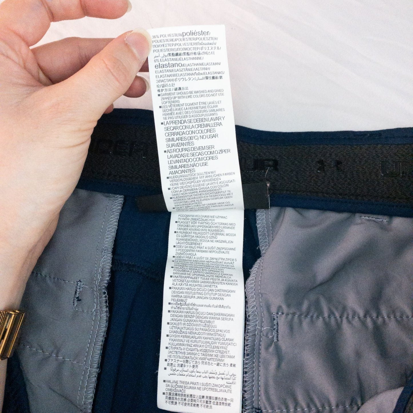 Under Armour navy men's shorts laid flat showing front and back views with button and logo details image 12