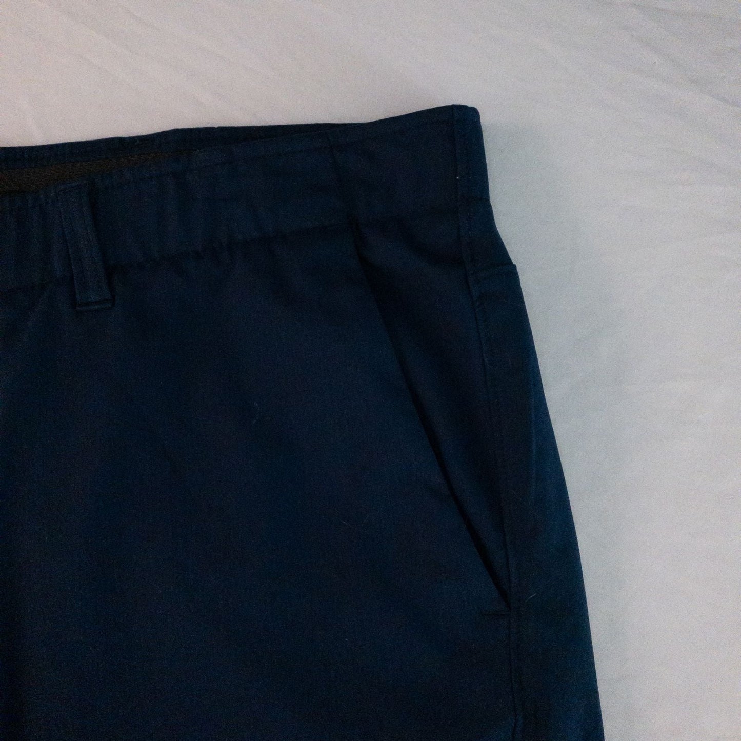 Under Armour navy men's shorts laid flat showing front and back views with button and logo details image 4