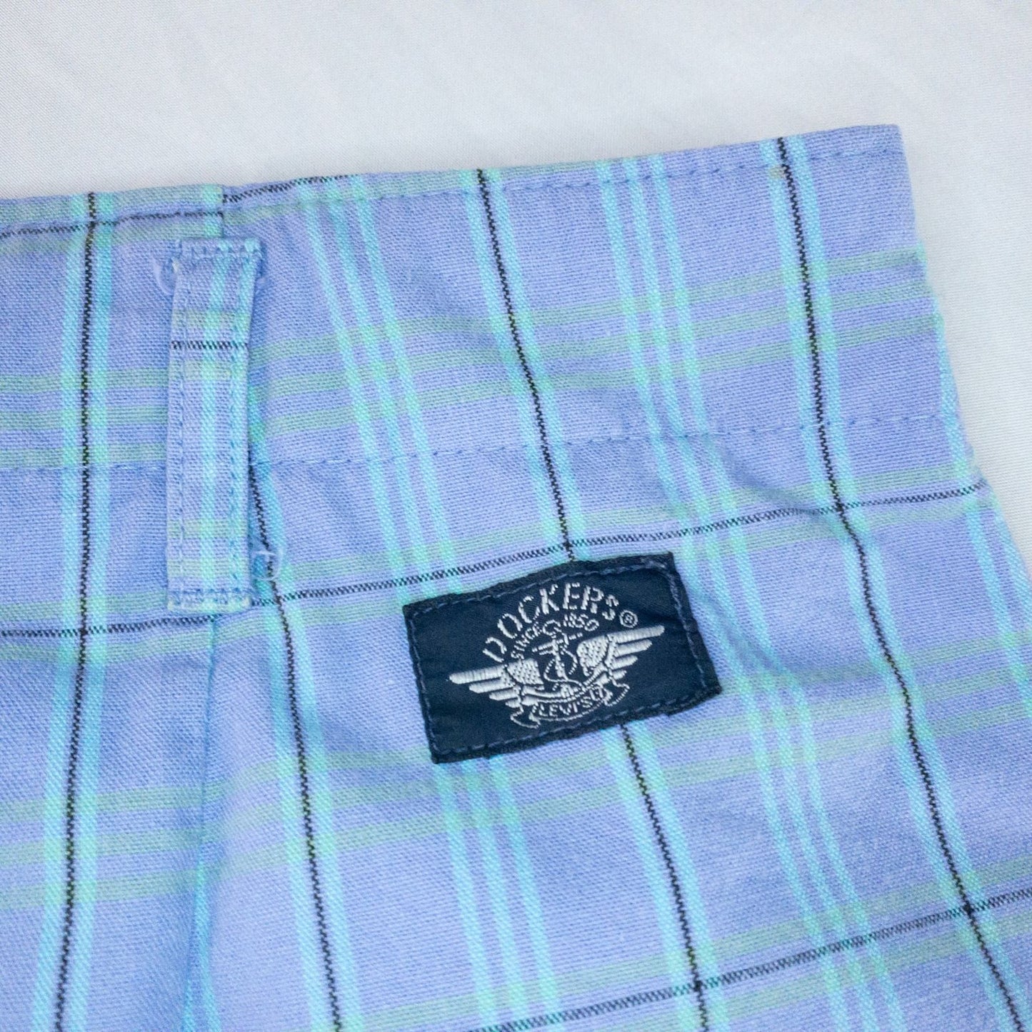 Levis Dockers purple plaid women's shorts laid flat showing front, side pockets, waistband details, and small wear dot image 10