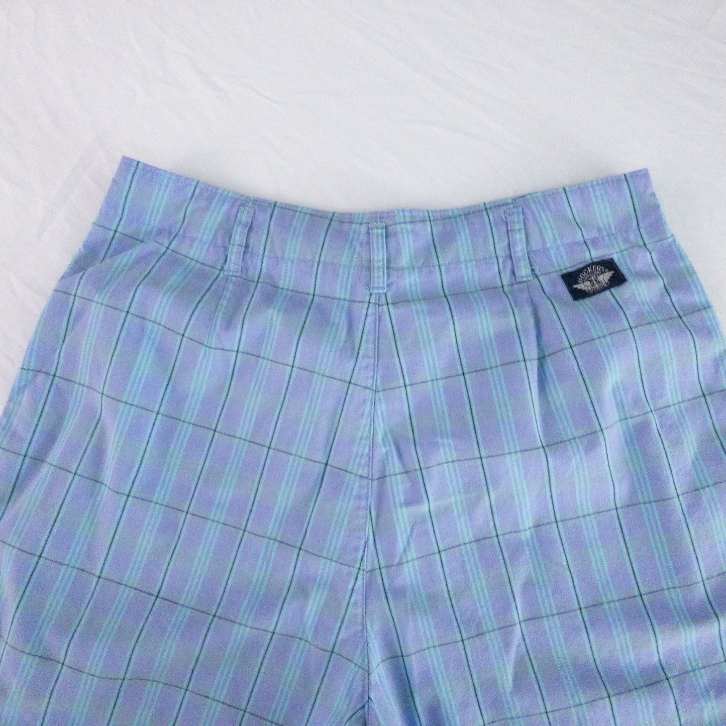 Levis Dockers purple plaid women's shorts laid flat showing front, side pockets, waistband details, and small wear dot image 9