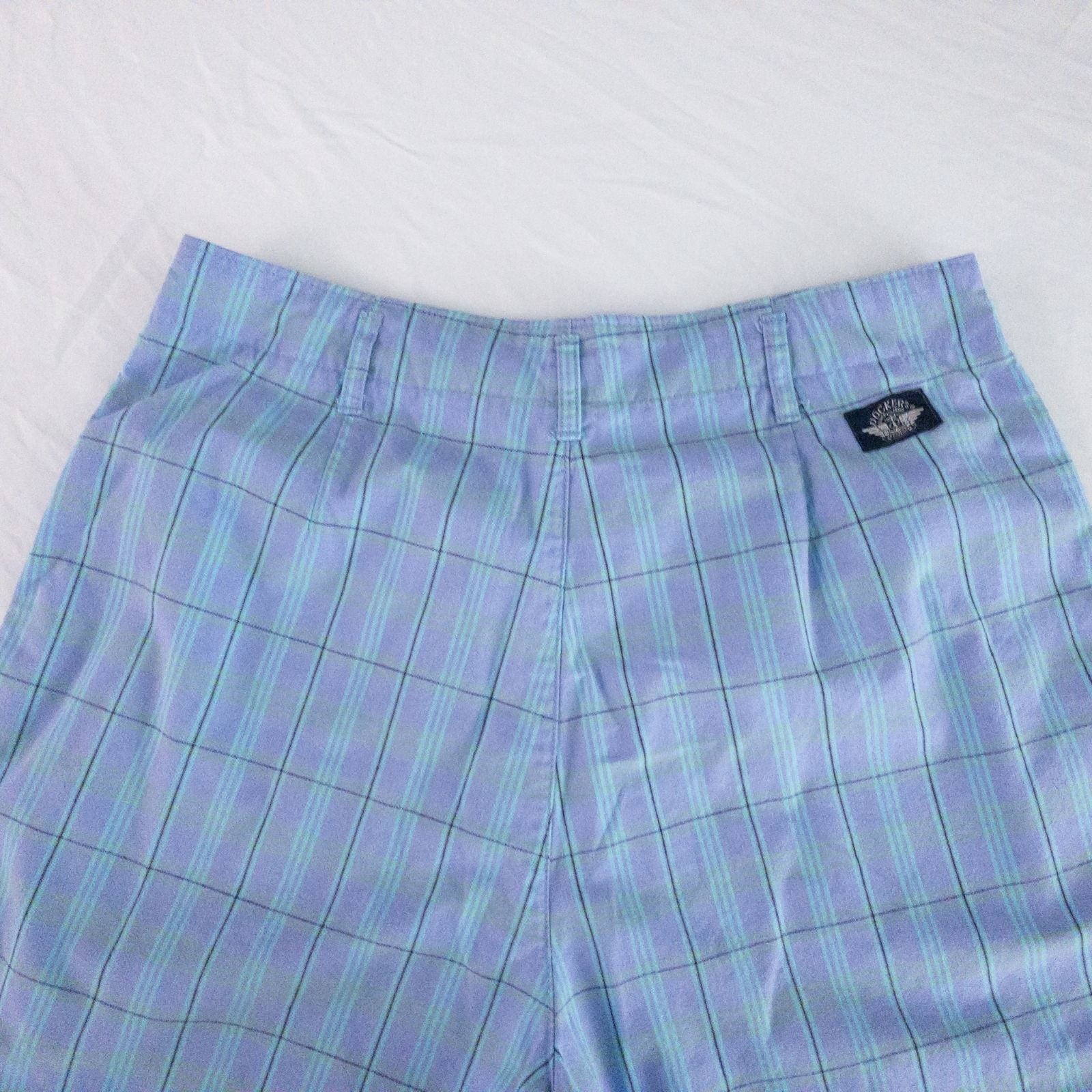 Levis Dockers purple plaid women's shorts laid flat showing front, side pockets, waistband details, and small wear dot image 9