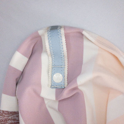 Lululemon striped neckwarmer scarf in white pink green tones displayed on a white mannequin head and laid flat showing snap closure image 7