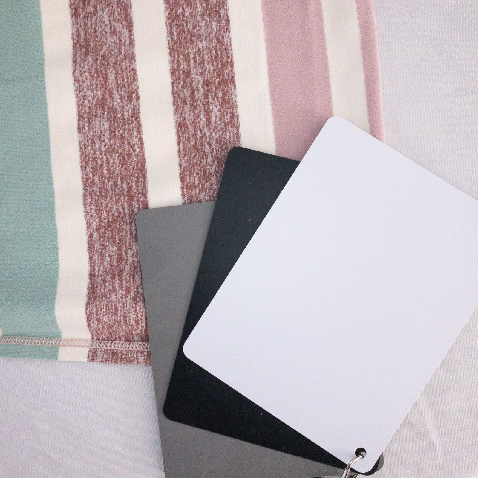 Lululemon striped neckwarmer scarf in white pink green tones displayed on a white mannequin head and laid flat showing snap closure image 9