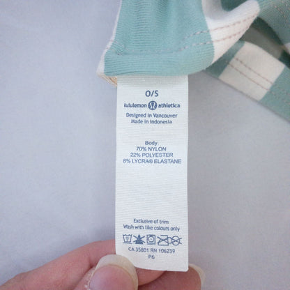 Lululemon striped neckwarmer scarf in white pink green tones displayed on a white mannequin head and laid flat showing snap closure image 10