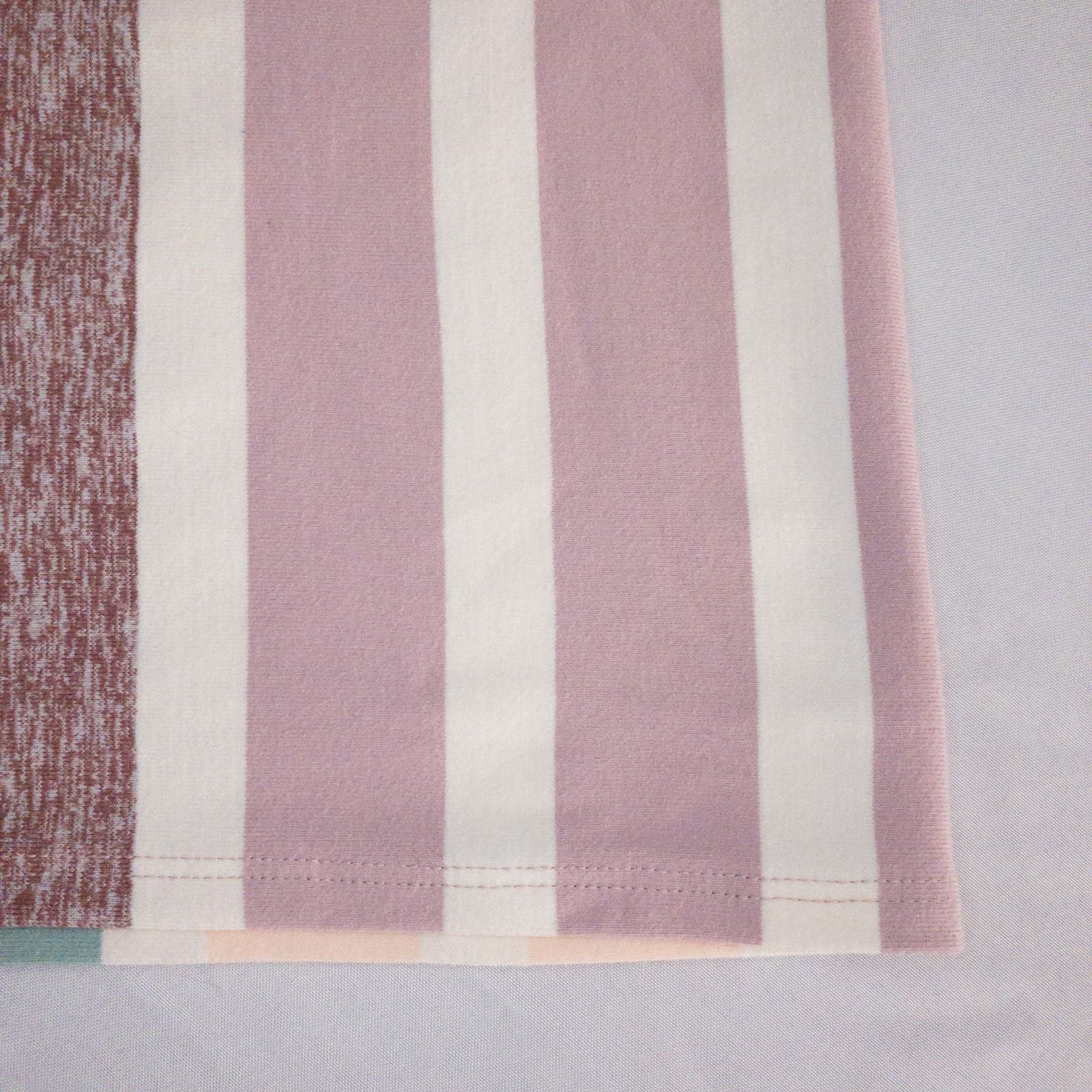 Lululemon striped neckwarmer scarf in white pink green tones displayed on a white mannequin head and laid flat showing snap closure image 5
