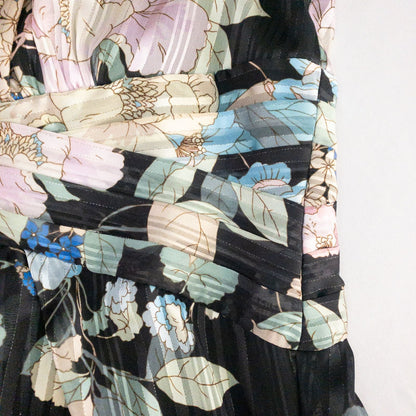 Adrianna Papell black floral maxi dress with twisted front detail hanging on clear hanger in front of white background image 10