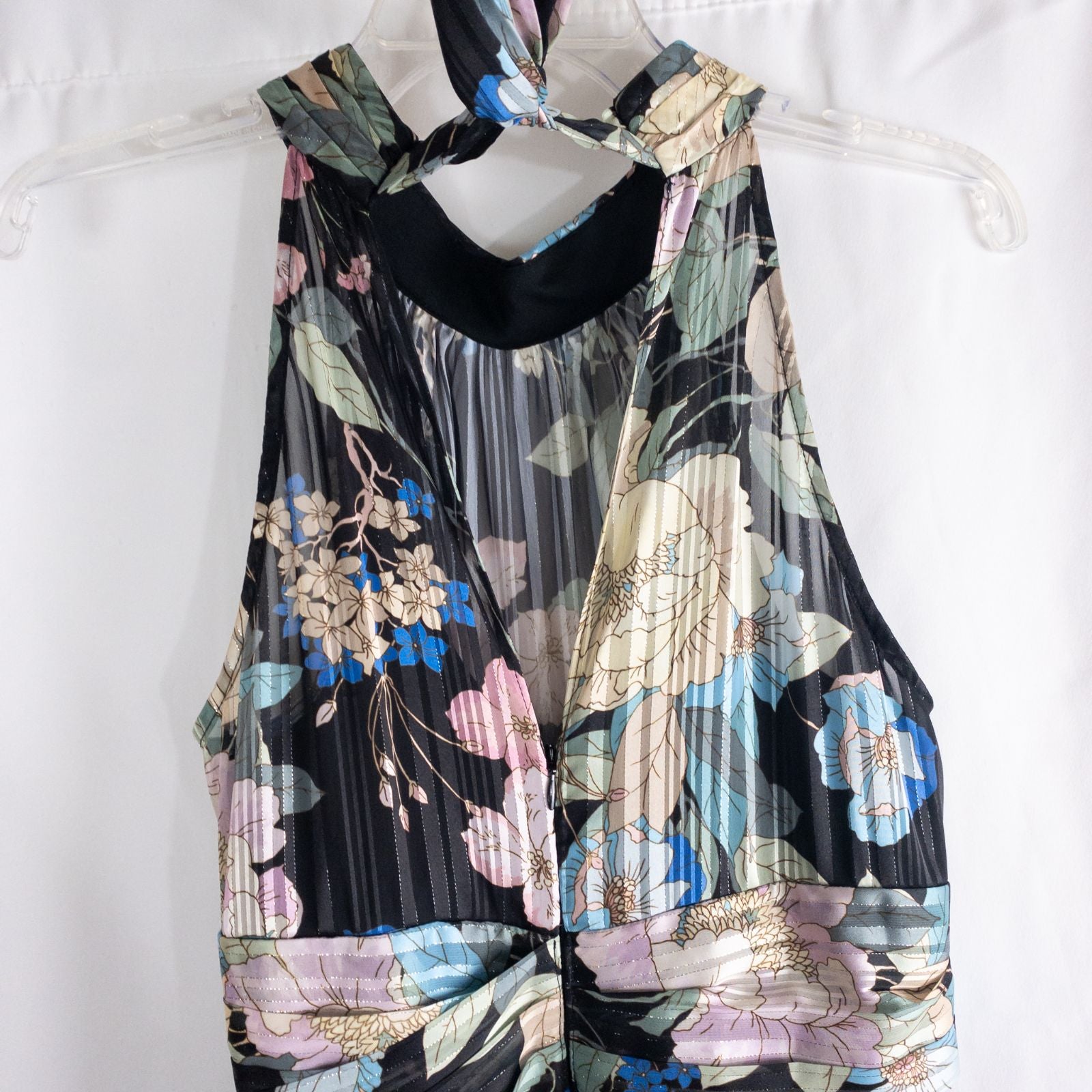 Adrianna Papell black floral maxi dress with twisted front detail hanging on clear hanger in front of white background image 8