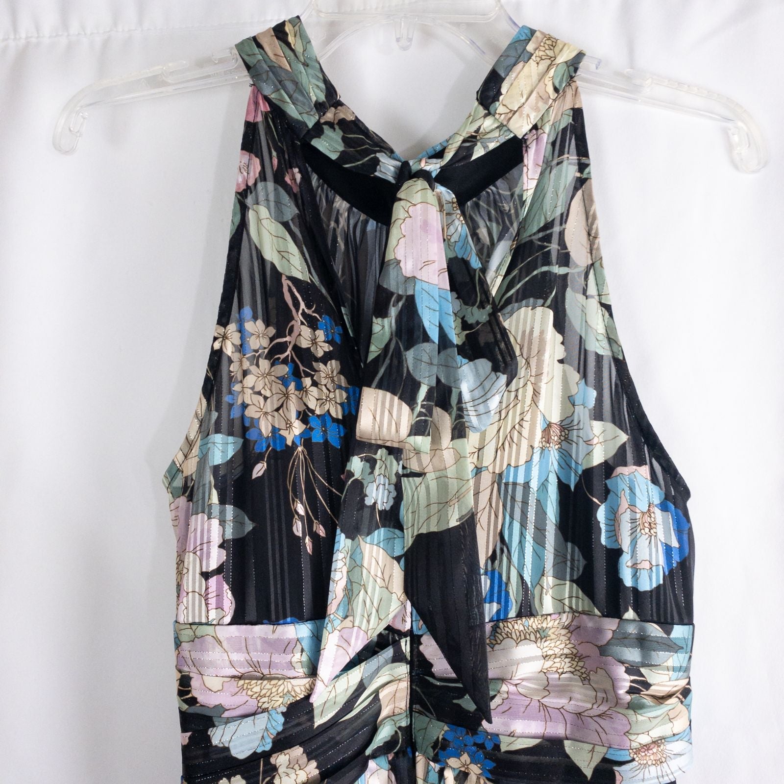 Adrianna Papell black floral maxi dress with twisted front detail hanging on clear hanger in front of white background image 7
